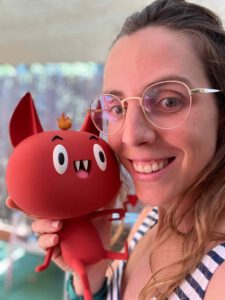 Foto Porträt von Ingrid Valls mit einer Puppe der Figur Belzi aus ihrer gleichnamigen Buchreihe